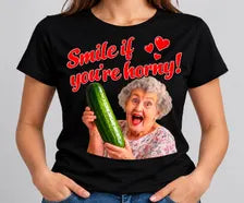 T-shirt preta Smile If You're Horny com frase vermelha e senhora a segurar um pepino.